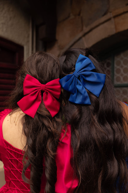 Woman wearing a sapphire blue hair bow from the gemstone collection with a matching dress