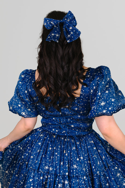 Model wearing starlight bow and matching star dress from behind