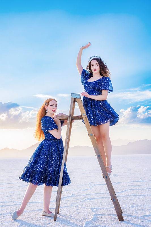 Model posing with hair bow and dress set in starlight theme
